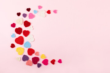 Multicolored crocheted hearts are laid out in the shape of the moon on a lilac background. Happy Valentine's Day, Mother's Day and birthday greeting card.