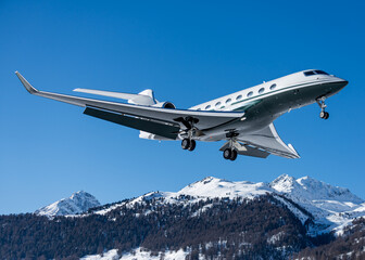 Fototapeta na wymiar Business jet during landing at Engadin airport during the winter holidays in Switzerland. The way to travel as a successful business owner