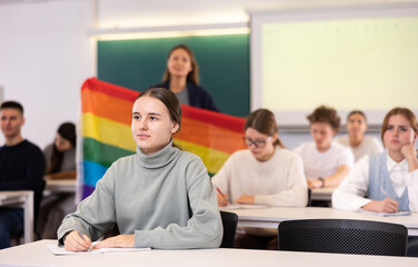 Fototapeta premium A young female student is carefully recording a lecture by a school teacher