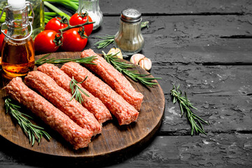 Raw sausages with herbs and tomatoes.