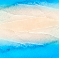 Fototapeta na wymiar Aerial view of transparent blue sea with waves on the both sides and empty sandy beach at sunset. Top view of sandbank. Summer travel in Zanzibar, Africa. Tropical landscape with white sand and ocean