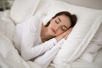 Fototapeta premium Young lady sleeping with hands under her head