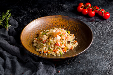 Fried rice with shrimp and vegetables on dark stone table