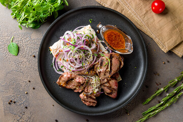 Beef kebab with red onion and tomato sauce top view