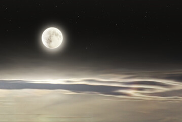 Fototapeta na wymiar Bright full moon with soft elongated clouds and stars at night