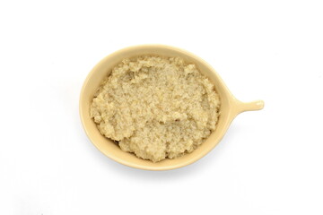Top view of a small bowl filled with artichoke dip isolated on a white background. Artichoke spread, pesto.