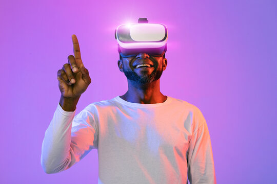 Joyful african american man touching something invisible, trying augmented reality