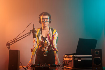 Musical artist with crazy make up having party to mix records and techno songs at tunrtables in...
