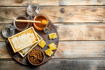 Honey in glass jars and honeycombs on the Board.