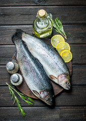 Raw fish salmon with lemon wedges and rosemary.