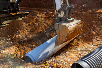 Concrete sewage pipes in ground so they can be installed underground are using tractor