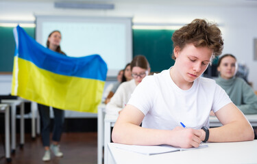 Fototapeta premium Teacher with the flag of Ukraine tells the history of the emergence of the state