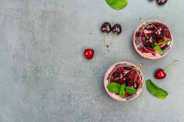 Delicious Italian dessert panna cotta with sweet cherry sauce, fresh berries and mint leaves