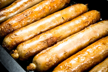 Fried sausages on a baking sheet.