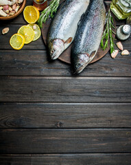 Raw fish salmon with herbs, spices and lemon wedges.