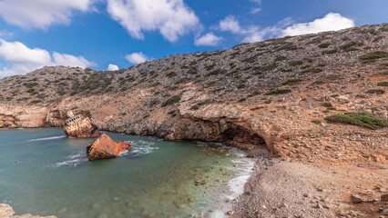 Naklejka premium An abandoned rusty ship in the sea timelapse near huge rock formations in Navagio Beach, Amorgos Island, Greece