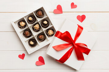 Delicious chocolate pralines in red box for Valentine's Day. Heart shaped box of chocolates top view with copy space