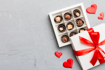Delicious chocolate pralines in red box for Valentine's Day. Heart shaped box of chocolates top view with copy space