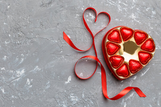 Delicious chocolate pralines in red box for Valentine's Day. Heart shaped box of chocolates top view with copy space - Powered by Adobe