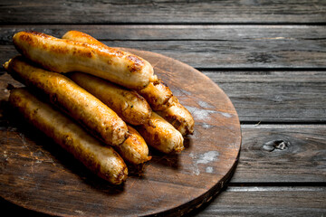 Grill beef sausages on a round Board.