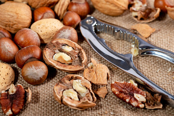 Open walnut and nutcracker on burlap. Close-up. selective focus