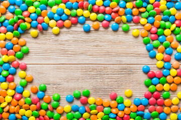 Mixed collection of colorful candy, on colored background. Flat lay, top view. frame of colorful chocolate coated candy