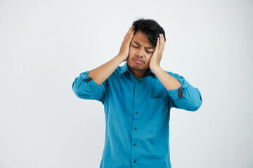dizziness or stress portrait young asian man holding head wearing blue shirt isolated on white background