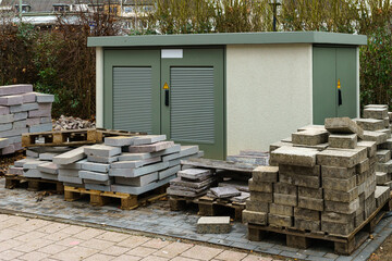 Paving slabs on wooden pallets in front of the electric power transformer.
