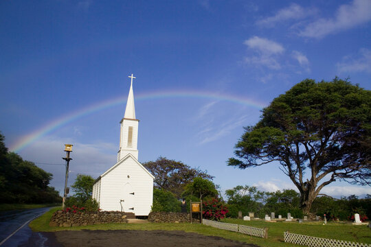 Tsunami warning system siren, church, cemetery and rainbow on the Pacific island of Molokai, Hawaii.