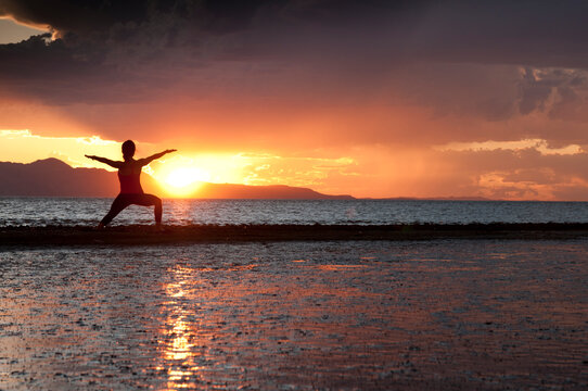 A young woman practices yoga on the shores of the Great Salt Lake, Utah.