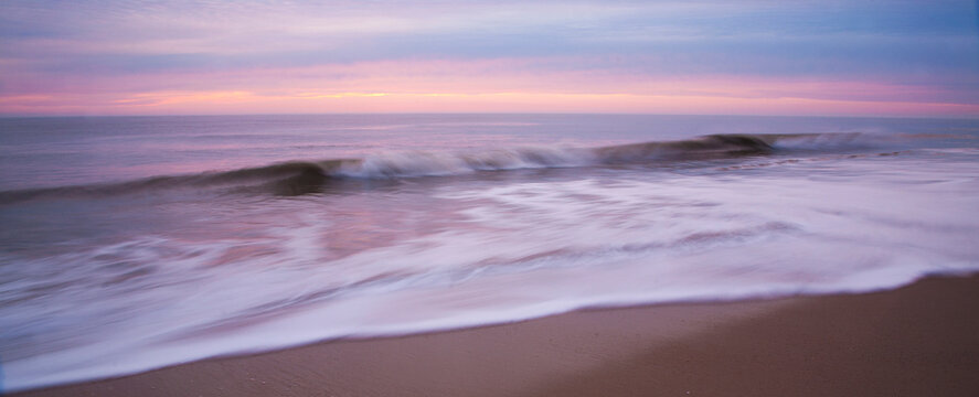 Crashing wave at dawn in Cape Henlopen State Park, Delaware, USA.