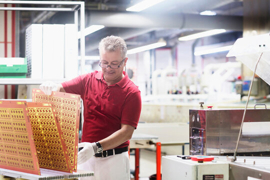 Male engineer examining circuit board in industry, Hanover, Lower Saxony, Germany