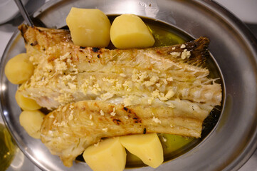 Grilled fillet of white codfish served with potatos in fish restaurant in Portugal