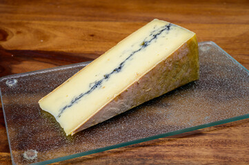 French semi-soft cow milk cheese morbier from Franche-Comte region with thin black layer and strong aroma