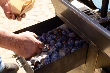 Roasting chestnuts on fire, Portuguese street food in autumn, Lisbon, Portugal