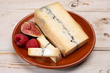 French semi-soft cow milk cheese morbier from Franche-Comte region with thin black layer and strong aroma