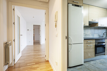 Hall of a house with access to the living room through a corridor and another access to a furnished kitchen