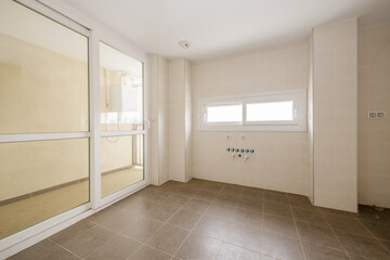 Empty room to install the kitchen with drying area with white aluminum and glass sliding doors