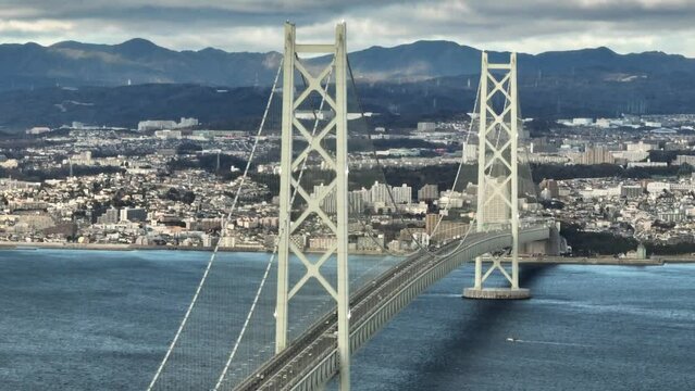 Aerial Rotation Over Light Traffic on Suspension Bridge to Coastal City