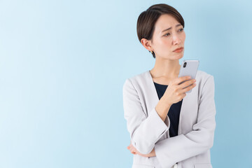携帯を持つスーツを着た日本人女性