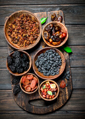 Assortment of different kinds of dried fruits in bowls.