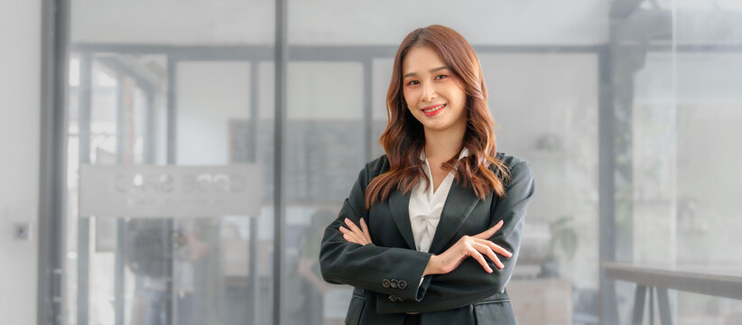 Confident asian business professional finance trader woman using trading app on laptop, sitting at monitor with trading infographics, charts, rates, chatting online, getting income, profit, smiling