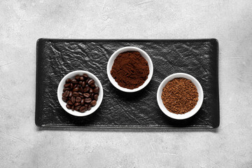Bowls with different types of coffee on light grey table, top view
