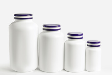 Row of different plastic medicine bottles on white background. Medicament