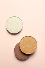 Different beautiful eye shadows on beige background, flat lay