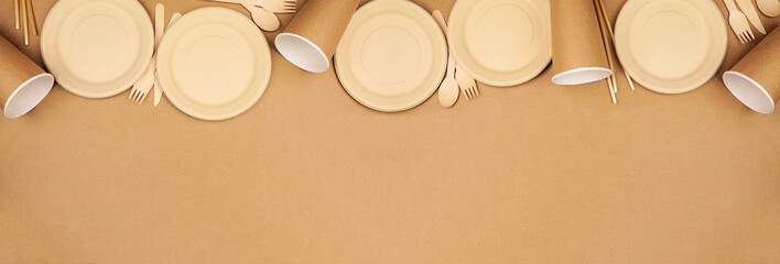 Eco friendly disposable dishware for takeout. Top border on a brown paper background....