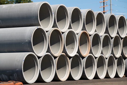 Reinforced concrete storm sewer pipes stacked at a construction site large diameter pipes