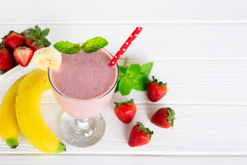 Strawberry and banana smoothie colorful fruit juice milkshake blend beverage healthy high protein the taste yummy In glass drink episode morning on  white wooden background.
