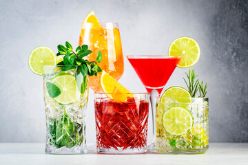 Most popular trendy cocktails set: aperol spritz, negroni, mojito, gin tonic and cosmopolitan on gray bar counter background - obrazy, fototapety, plakaty