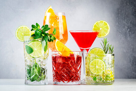 Most popular trendy cocktails set: aperol spritz, negroni, mojito, gin tonic and cosmopolitan on gray bar counter background